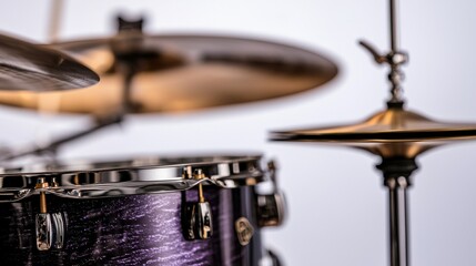 Obraz premium A close-up view of a drum set featuring a shimmering purple drum and a bright cymbal, highlighting the details of musical instruments.