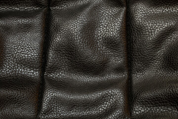 Black leather texture with a characteristic grain pattern and surface shine, black grain leather
