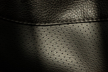 Texture of black perforated leather with small holes and textured surface, black leather