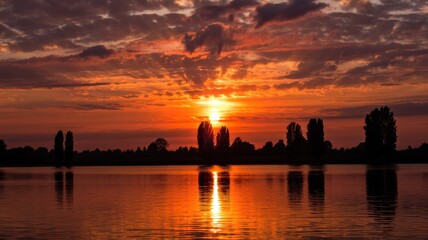 Fototapeta premium Lake sunset with trees silhouette
