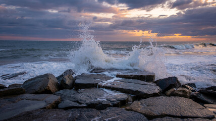 Waves crash and spray over a rocky jetty