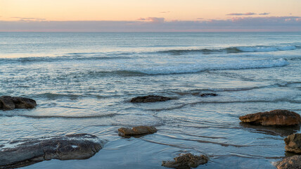 Naklejka premium Waves roll over rocks in a shallow bay