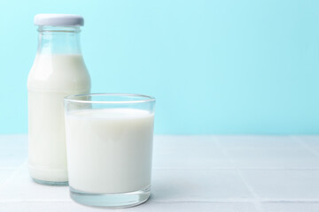 Fresh milk on white table against light blue background. Space for text