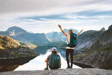 Couple friends traveling in Norway man and woman hiking enjoying Lofoten islands view, active vacations healthy lifestyle recreation trip outdoor family backpackers adventure climbing tour
