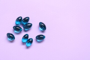 Collagen capsules on violet background, flat lay. Space for text