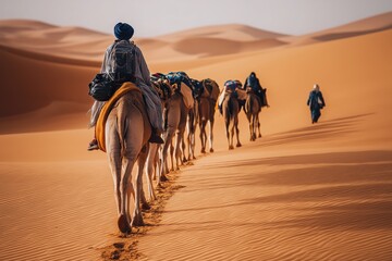 Fototapeta premium Berber Man Leading Camel Caravan Across Sand Dunes