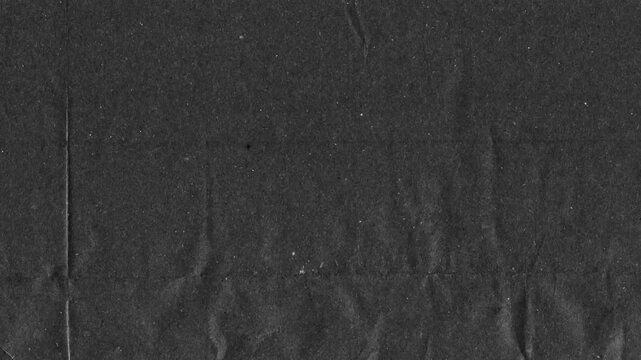Black kraft paper noise texture 4K stop motion video. Aged old page overlay effect background loop animation. Vintage paper texture with crease, stain, grain, dust particles. Empty animated backdrop
