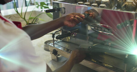 Image of light spots over biracial man preparing coffee in cafe