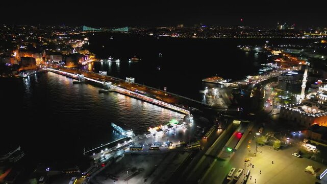 Aerial half-circle above Galata Bridge and Istanbul's illuminated coast