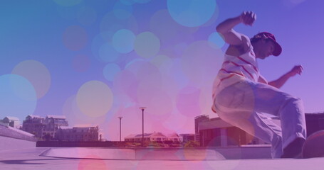 Image of colourful spots over caucasian man skateboarding