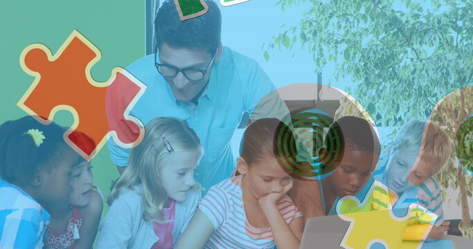 Image of puzzle pieces over diverse schoolchildren and teacher using laptop - Powered by Adobe