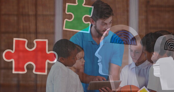 Image of puzzle pieces over diverse schoolchildren using tablet