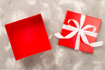 Open red gift box on concrete background, top view