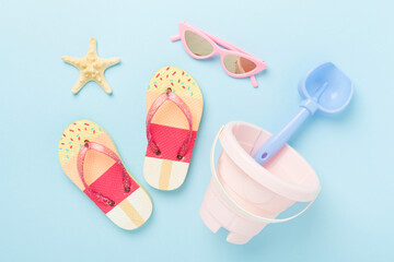 Children's flip flops and beach toys on color background,,top view