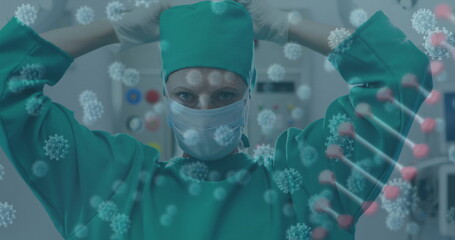 Adjusting surgeon tightening cap straps above head in operating room, with coronavirus graphics