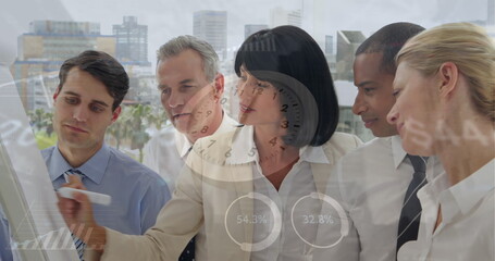 Image of data processing and clock over diverse business people taking notes