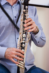  A fragment of a bass clarinet in the hands of a musician