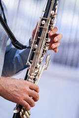 A fragment of a bass clarinet in the hands of a musician