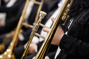A fragment of a trombone in the hands of a musician in an orchestra