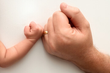 Two hands: man and child. Father and son touching fists. Dad and newborn son boys holding hands together. Little and big fists of father and son. 