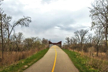 The North Branch Trail climbs to a distant bridge beneath a cloudy sky on a Spring day near Chicago, Illinois.