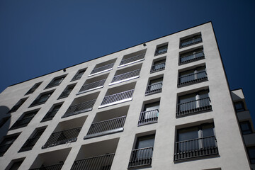 A Modern Apartment Building Stands Tall Against a Sleek and Clear Blue Sky Above It