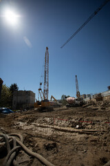 Construction site bustling with machinery under a clear sky, showcasing a busy urban landscape
