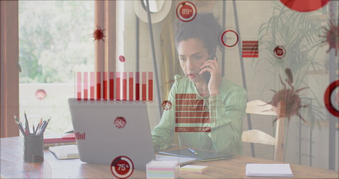 Image of covid 19 cells and statistics over biracial businesswoman using phone and laptop