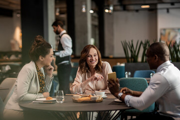 Business colleagues having breakfast meeting in modern hotel restaurant setting