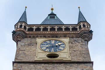 View of old tower with a clock on sky background in Old Town of Prague city.