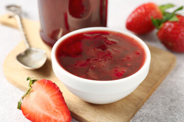 Delicious strawberry sauce and fresh berries on light table, closeup