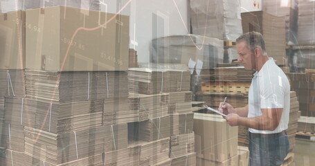 Image of financial graphs over caucasian male warehouse worker making notes