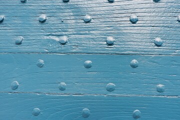 A close-up view of a blue wooden surface featuring evenly spaced raised dots