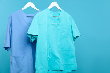 Medical workers uniforms on hangers against blue background