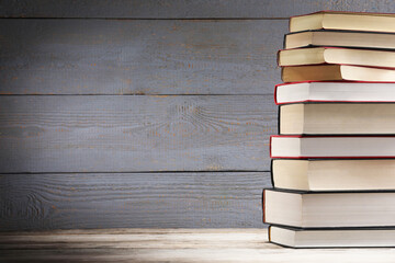 Stack of old books on wooden table, space for text
