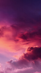 Obraz premium A stunning vertical view of vibrant pink and purple clouds painted across the evening sky creates a breathtaking and dramatic colorful scene at twilight hour.