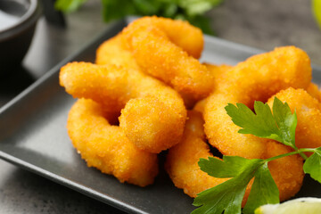 Tasty tempura shrimps and parsley on grey textured table, closeup