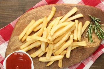 Tasty french fries with ketchup and rosemary on wooden table, top view