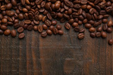 Aromatic coffee beans on wooden table, top view. Space for text