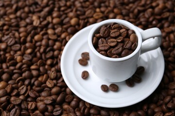 Cup and saucer on coffee beans, closeup. Space for text