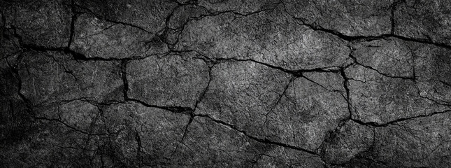 textured black and gray grunge background featuring cracked stone patterns, evoking sense of depth and ruggedness. This is perfect for various design projects