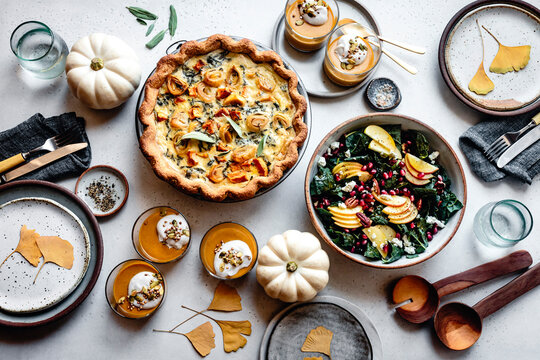 Fall holiday meal with quiche and sald and pumpkins