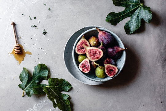 Fresh Figs in a bowl with honey on a marble background with copy space
