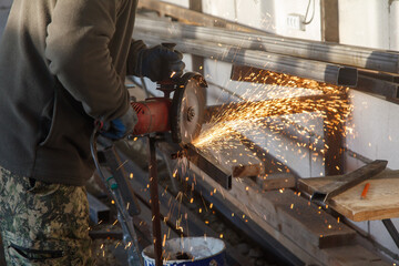 A man is cutting metal with a saw