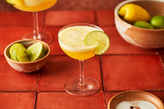 Pineapple Lime Margarita on terracotta tile surface with chilli salted rim