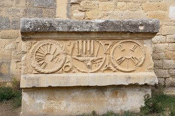 Historical Roman numerals carved in stone depict ancient timekeeping and measurement methods