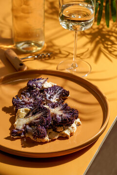purple cauliflower with b&eacute;chamel sauce, on yellow mustard background, hard light