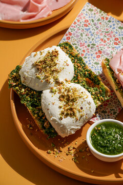 delicious  Italian Mortadella Sandwich with Pesto and Mozzarella basil pesto, crusty ciabatta bread, yellow background