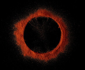 Spicy chili red pepper, milled dry paprika pile in shape circle, isolated on black background, top view, clipping path