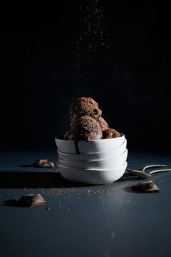 Black Cocoa Ice Cream in a Stack of Bowls on a Dark Blue Background